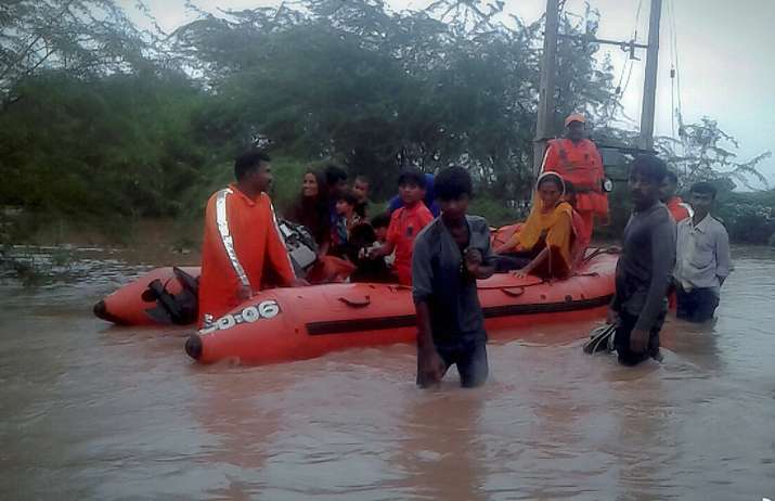 NDRF men rescuing people in a village in Gujarat's Morbi