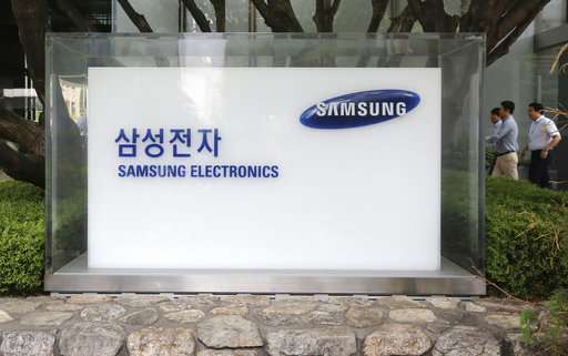 employees walk by the Seoul office of Samsung Electronics