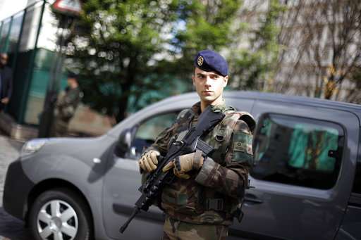 A French soldier stands guard near the site where a vehicle