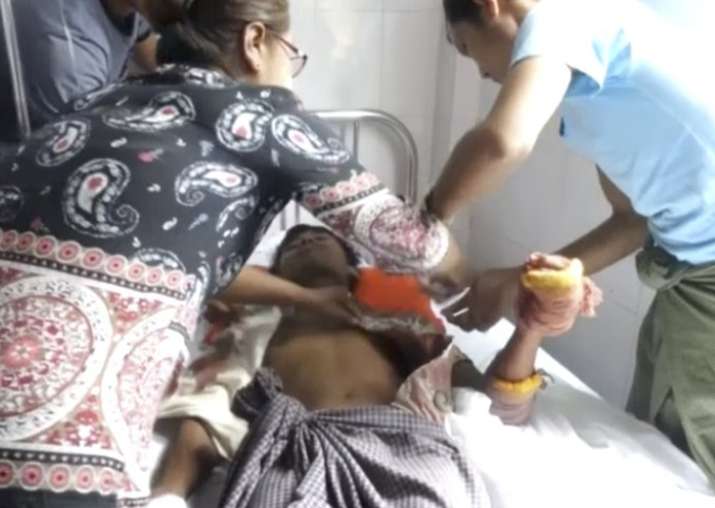 A man lying on a bed in a hospital in Buthidaung township,