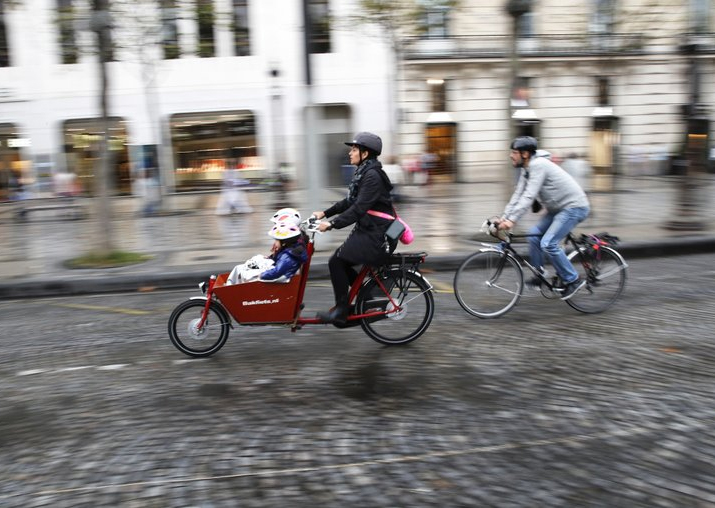 Pice - A woman and a man ride their bicycles on the Champs
