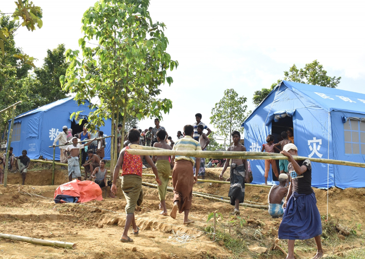 File pic - People walk near Chinese relief tents at a camp