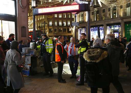 Police officers and Transport for London workers stand at