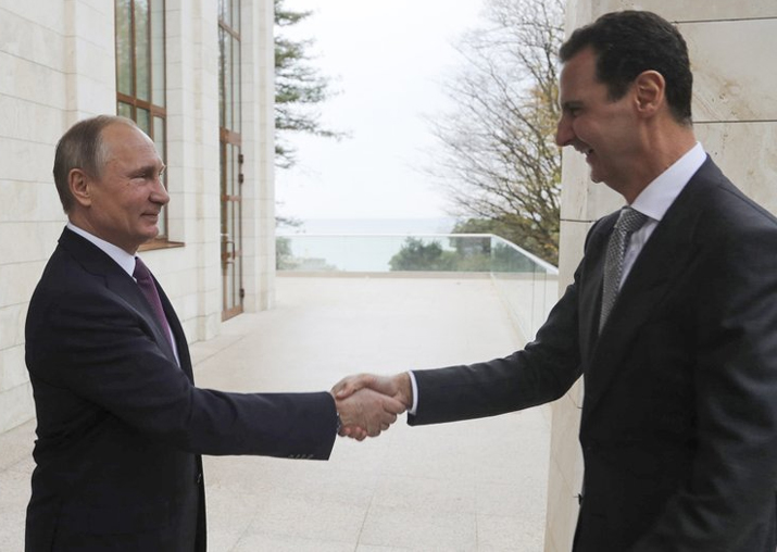 Vladimir Putin shakes hand with Bashar Assad in the