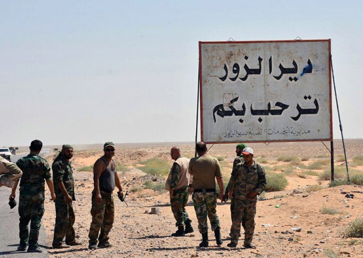 Syrian troops and pro-government gunmen standing next to a