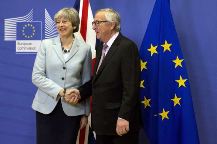 British PM Theresa May, left, is greeted by European