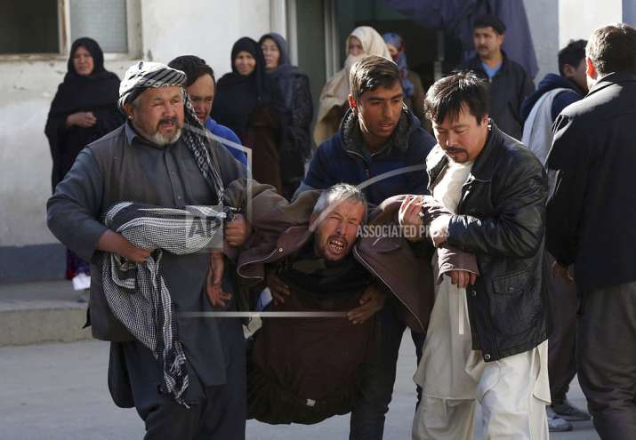 A distraught man is carried following a suicide attack in