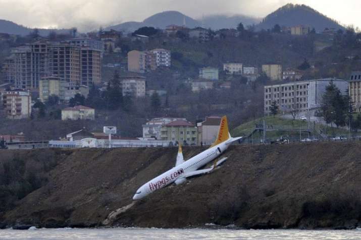 Plane dangles off cliff after skidding off runway in