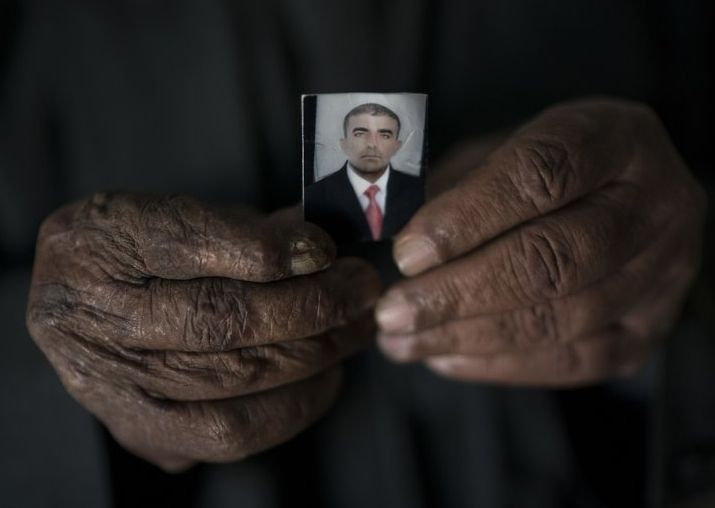 Ghanim Ahmed holds the photo of his son Ghazwan Ahmed, who