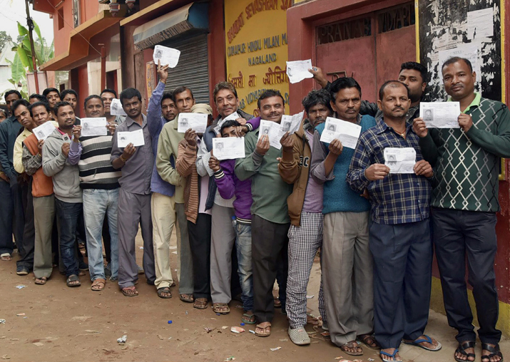 Voters wait in a long queue to cast their votes for