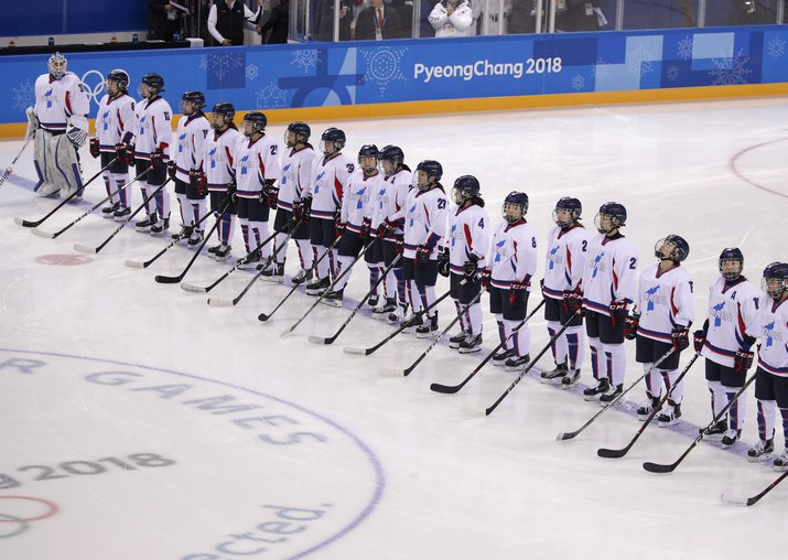 Players from the combined Koreas line up before the