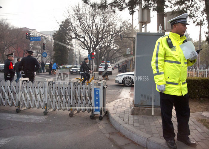 Chinese policemen stand guard at a road barricade in front