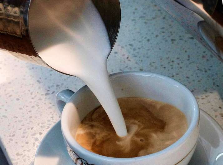 Â A barista pours steamed milk in a coffee at a cafe in Los