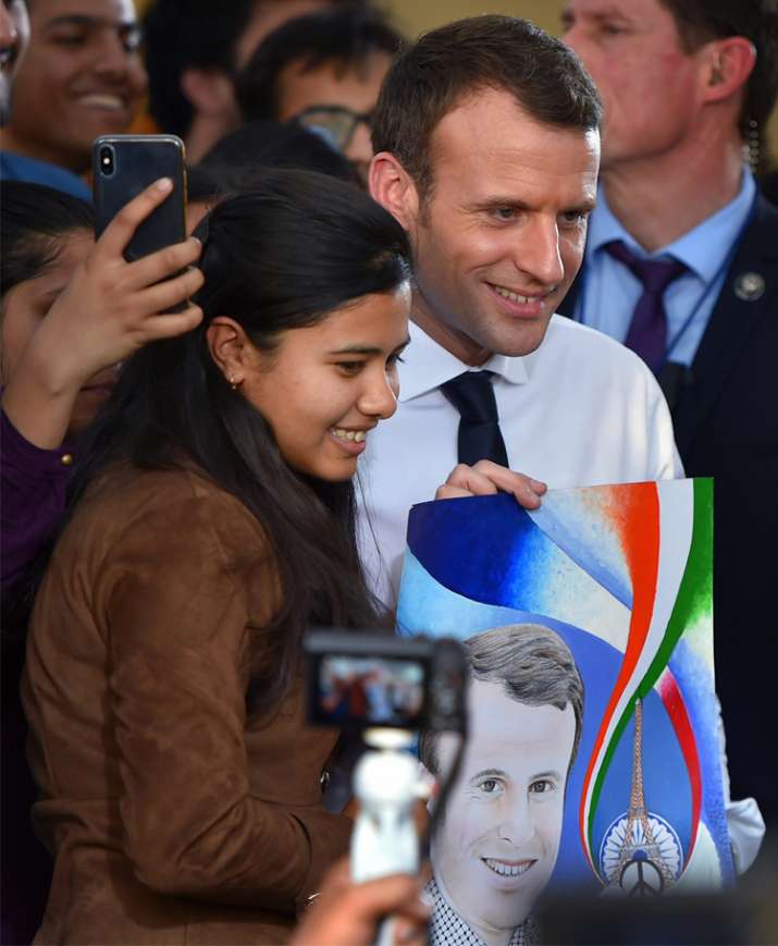 India Tv - French President Emmanuel Macron poses for a photo with students at Bikaner House in New Delhi on Saturday.