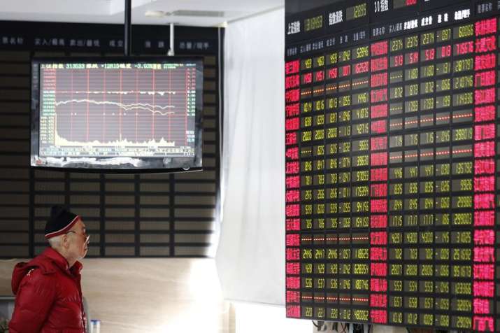 An investor looks at a stock price display screen at a