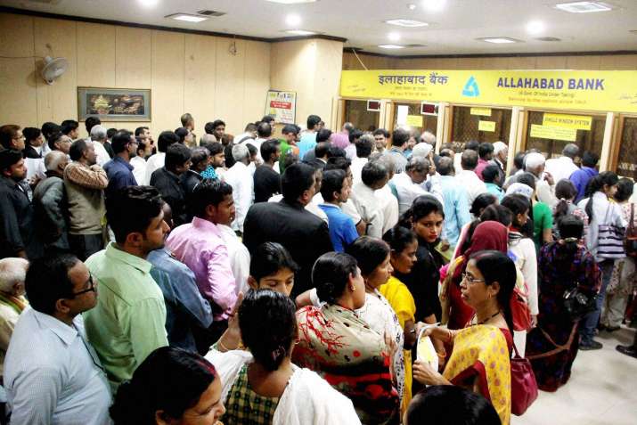 People gather inside a bank to exchange high-denomination