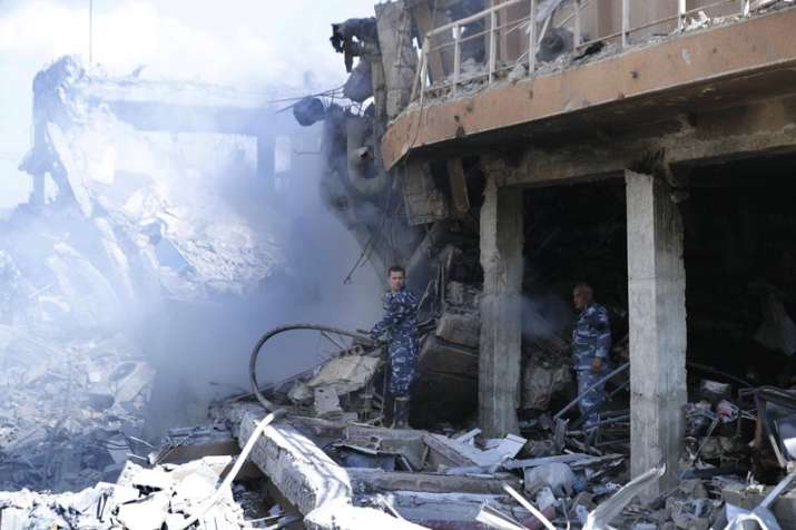 India Tv - Firefighrers extinguish smoke that rises from the damage of the Syrian Scientific Research Center which was attacked by US, British and French military strikes to punish President Bashar Assad for suspected chemical attack against civilians, in Barzeh, near Damascus, Syria, Saturday, April 14, 2018.