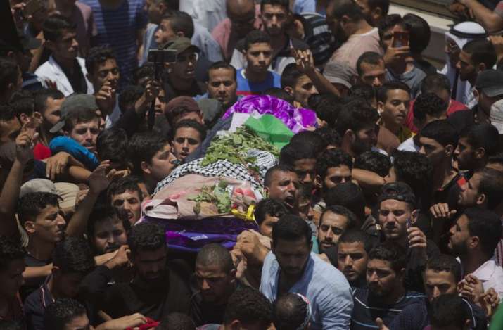 Palestinian mourners carry the body of a volunteer