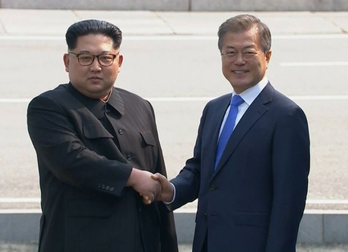 North Korean leader Kim Jong Un, left, shakes hands with