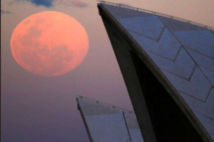   India Tv - A supermoon rises behind the roof of the Sydney Opera House 