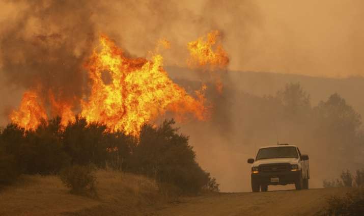India Tv - A truck passes by flames during the Ranch Fire in Clearlake Oaks, California, on Sunday,
