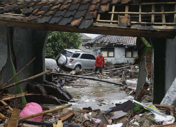 A man walks near debris at a tsunami-ravaged area in