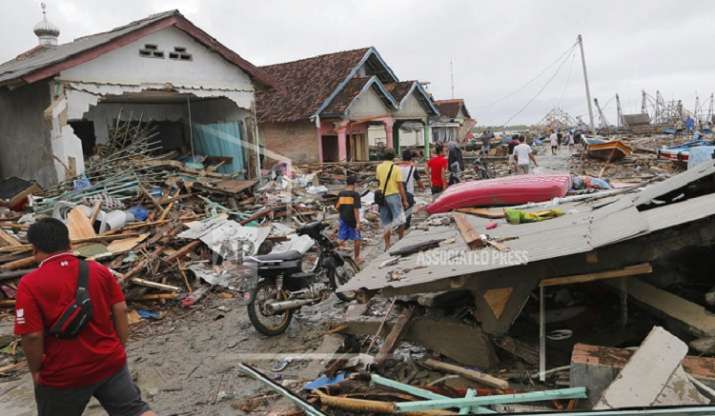 India Tv - People inspect the damage at a tsunami-ravaged village in Sumur, Indonesia. (AP Photo/Tatan Syuflana)