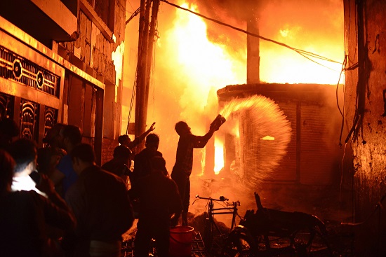 Firefighters and local people help to douse a fire in