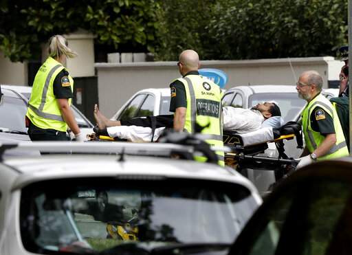 Ambulance staff take a man from outside a mosque in central