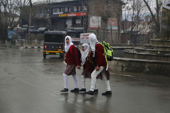 India Tv - Kashmiri school girls walk to their school early morning in Srinagar, Monday, March 11, 2019. Schools in Indian Kashmir reopened Monday after a three months winter break. (AP Photo)  