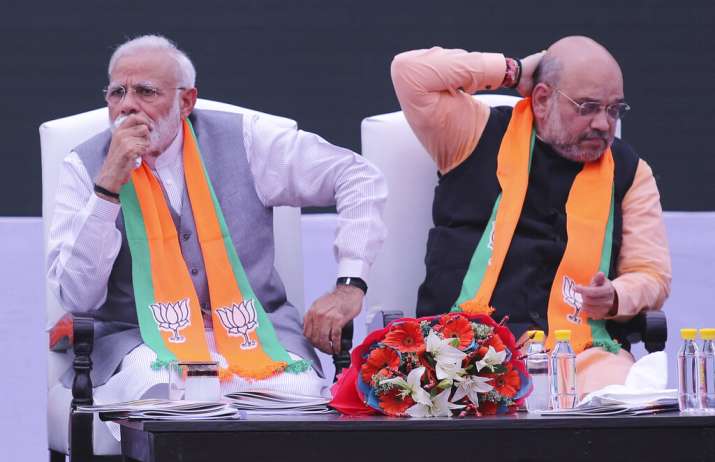 India Tv - Prime Minister Narendra Modi, left, with Bharatiya Janata Party (BJP) president Amit Shah listen to Indian Home Minister Rajnath Singh during the release BJP's manifesto for the upcoming general elections in New Delhi, India, Monday, April 8, 2019.