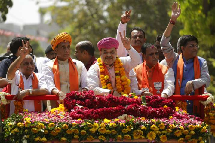 India Tv - Bharatiya Janata Party (BJP) president Amit Shah, center, flashes a victory sign during a road show before filing his nomination for upcoming general elections in Ahmadabad, India, Saturday, March 30, 2019. India's national elections will be held in seven phases between April 11 and May 19. 