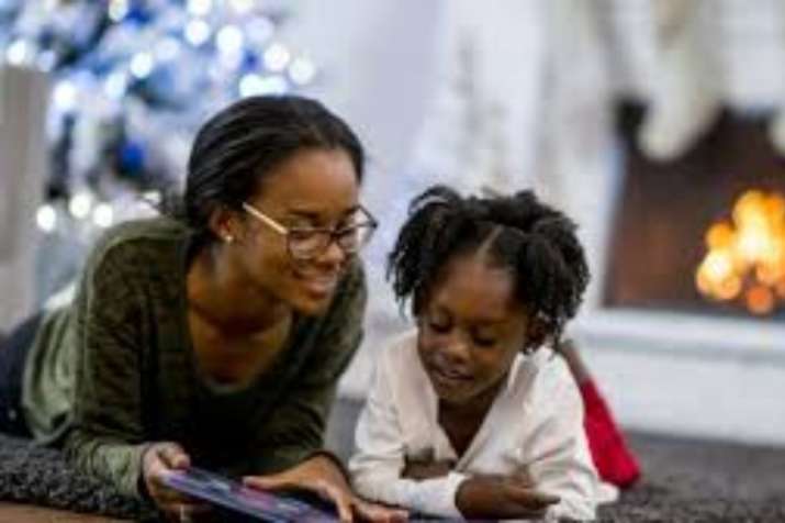 Parent and kid reading book together