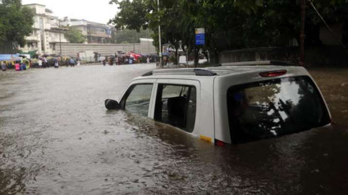 India Tv - A car is seen submerged in a flooded street following heavy rains in Mumbai.