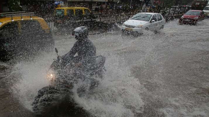 India Tv - A motorcyclist speeds through a waterlogged street as most of the city's roads were flooded and drains overflowed due to continous rains.
