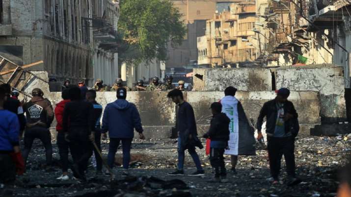 Anti-government protesters gather near barriers set up by security forces to close Rasheed Street du