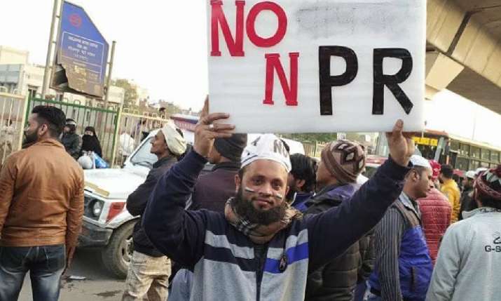 A protestor holds a banner at Jafrabad protest site on