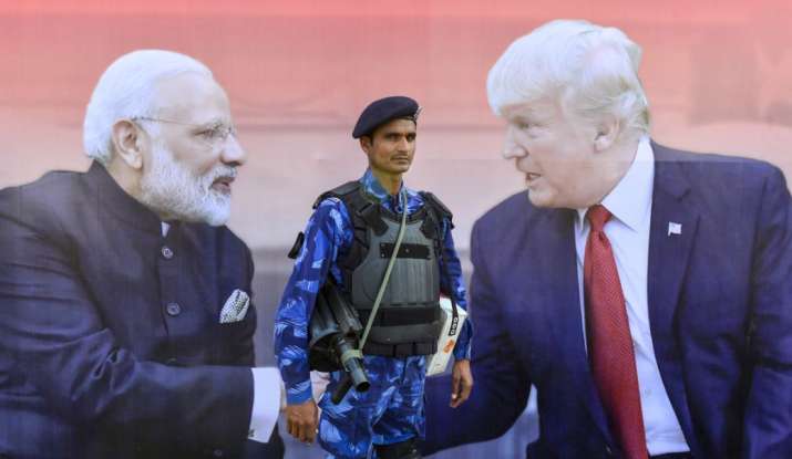 India Tv - A security man stands guard near a bill board showing pictures of Prime Minister Narendra Modi and U