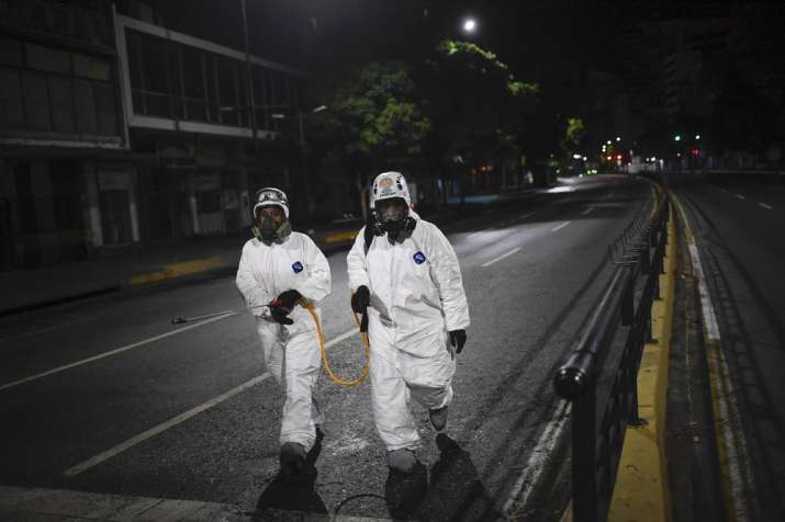 City workers walk after spraying disinfectant on the streets as a preventive measure against the spr