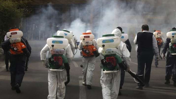 A file photo of health workers spraying disinfectants on