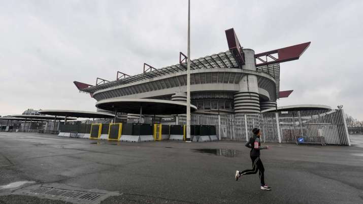 A woman jogs outside San Siro stadium where a Serie A