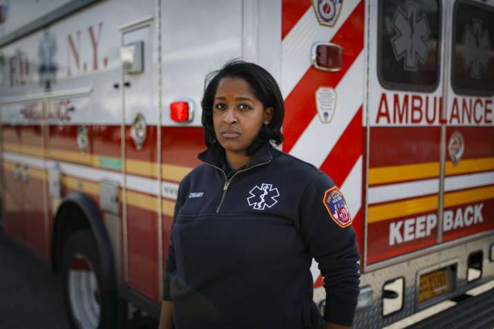 In this April 7, 2020, photo, Virginia Creary, a 911 dispatcher, stands for a portrait outside her s