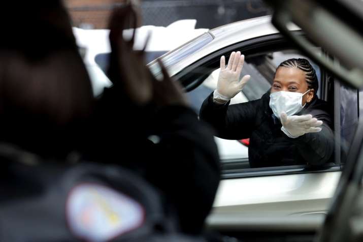 Chicago Police officer Cheryl Clark, right, greets co-workers while she is waiting to get vital PPE