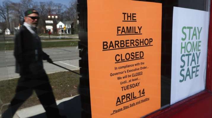 A pedestrian walks by The Family Barbershop, closed due to
