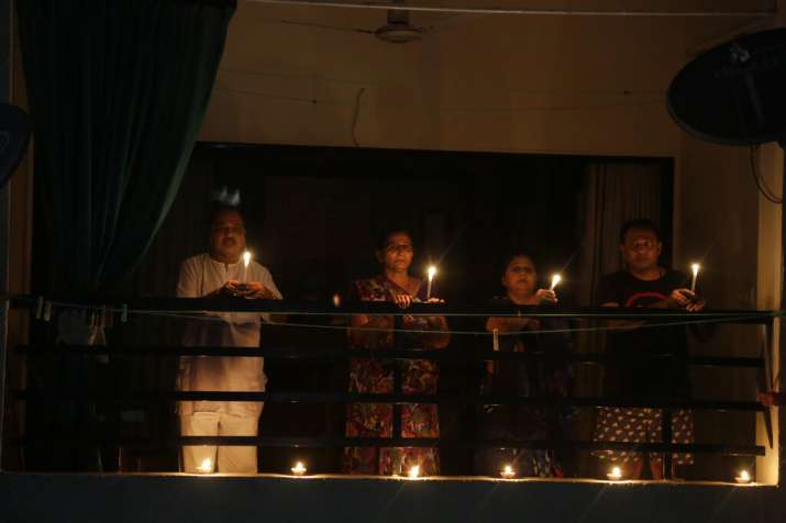 India Tv - A family holds candles to mark the country's fight against the Covid-19 pandemic in Ahmedabad, Sunda