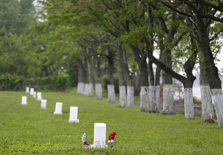 India Tv - White markers, each indicating a mass grave of about 150 people, are displayed on Hart Island in New