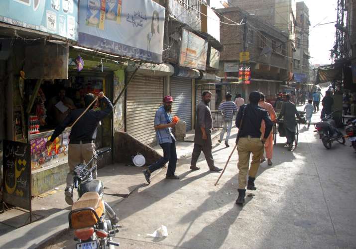 Police officers try to restrict people from defying the nation-wide lockdown to curb the spread of t