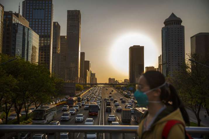 A woman wears a face mask to protect against the spread of the new coronavirus as she walks across a