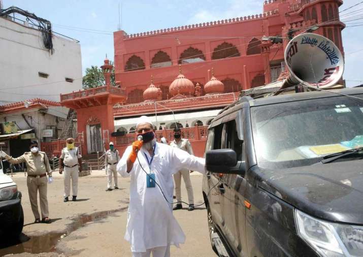 A Muslim devotee makes announcements urging members of the