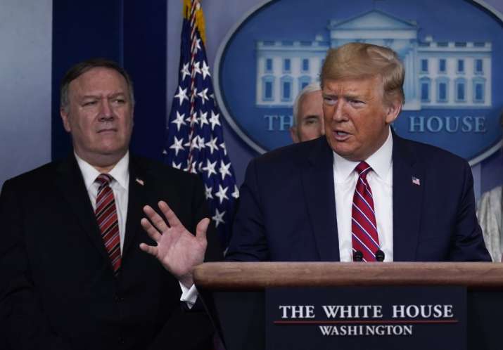 In this March 20, 2020, file photo, with Secretary of State Mike Pompeo to the rear, U.S. President